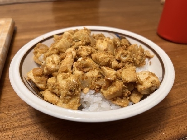 A bowl of curry yogurt chicken over rice.