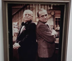 A framed photo of Don Rickles and Bob Newhart, two older white men, standing back to back.
