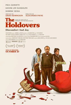 The Holdovers poster. A quasi-photorealistic drawing, featuring three people standing in a row behind an oversized smashed christmas ornament. In front is Paul Giamatti, a middle aged white man, to his left is Dominic Sessa, a shaggy young white man, and to his right is Da'vine Joy Randolf, a middle aged black woman.