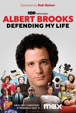 Defending my life poster. Albert Brook's head, a white man with a curly afro, circa 1975, a young man. He stares implacably into camera. Various smaller images of him throughout his career adorn the bottom of the frame.