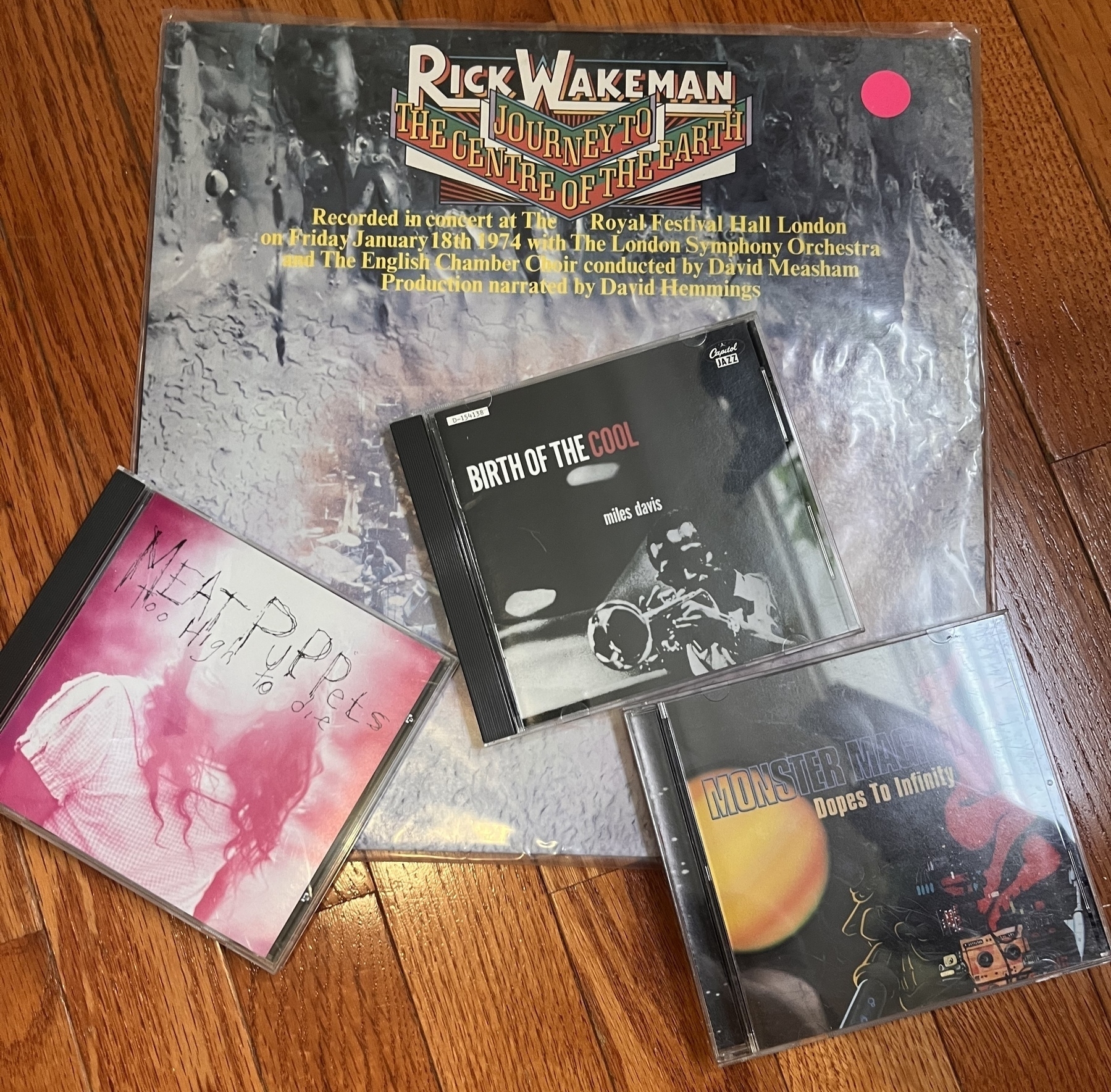Four music albums are displayed, including one vinyl titled Rick Wakeman The Journey to the Centre of the Earth and three CDs: Miles Davis: Birth of the Cool, Meat Puppets: Too High to Die, and Monster Magnet: Dope’s to Infinity.