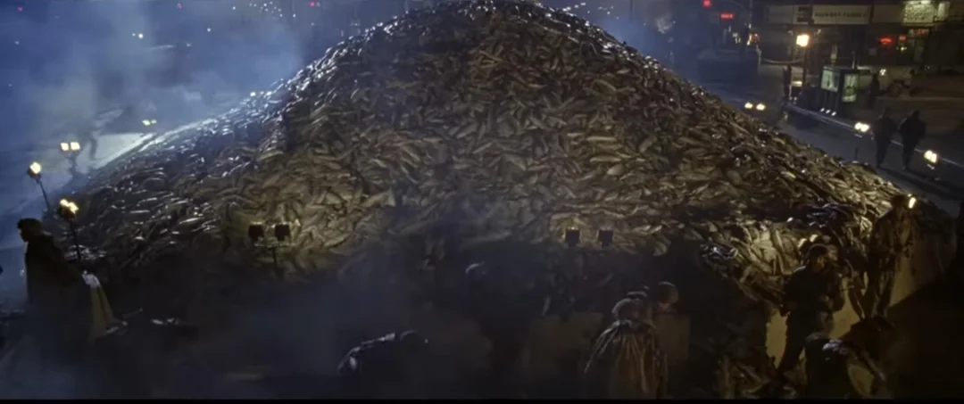 Auto-generated description: A large mound of potatoes is lit by streetlights in an outdoor urban setting at night.